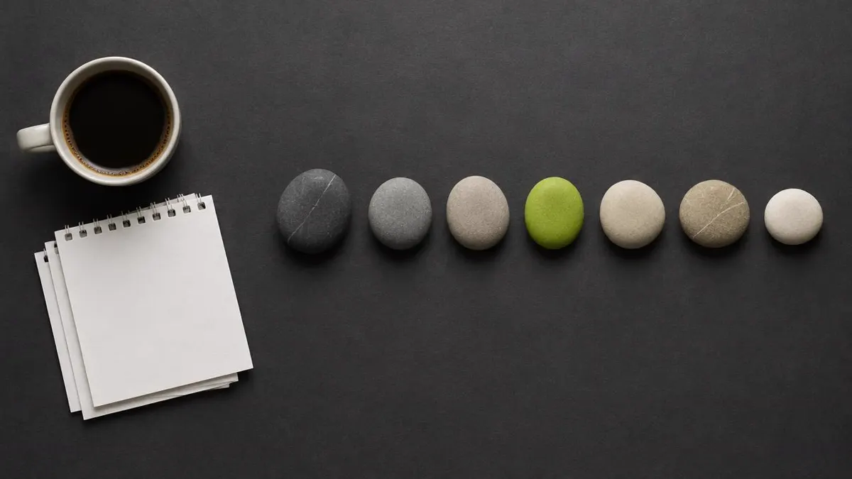 Minimalist editorial composition featuring a coffee cup, calendar pages, and a sequence of seven small neutral objects arranged to suggest the passage of time